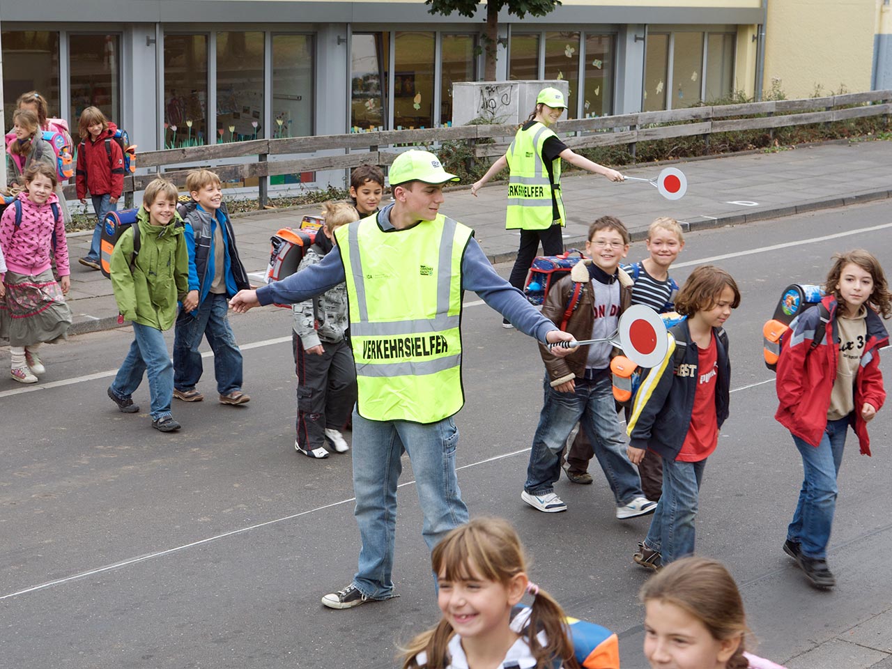 Verkehrshelfer helfen Schulkindern über die Straße